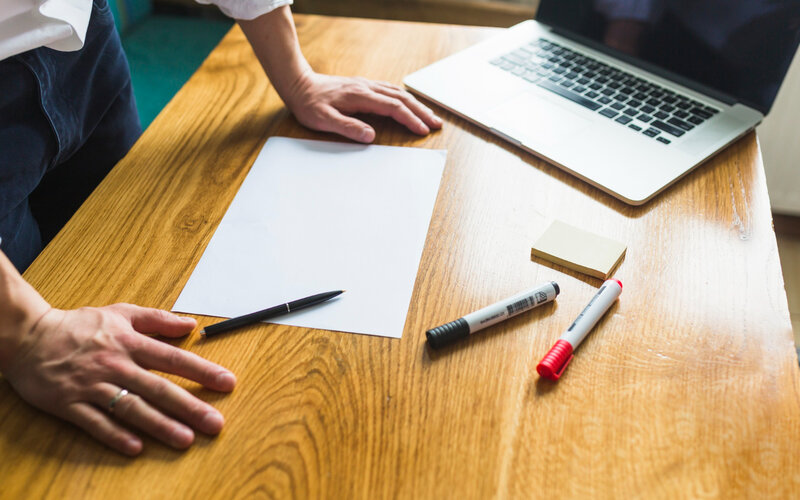 Startup team mapping metrics to data sources on paper and laptop
