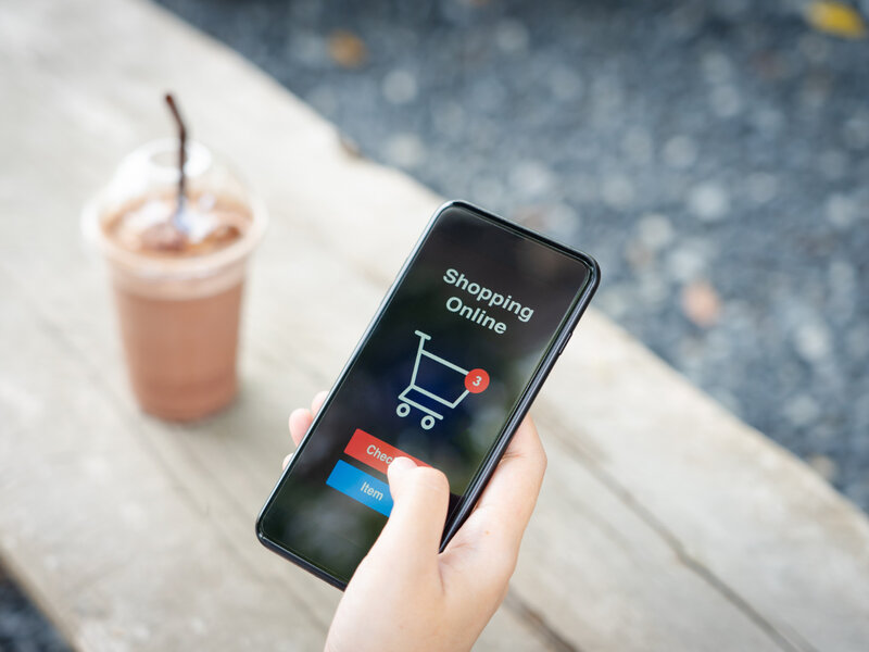 Hand holding phone showing mobile shopping checkout process