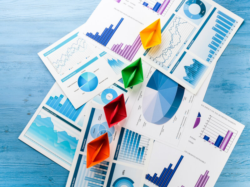Paper boats on colorful business charts illustrating vanity growth