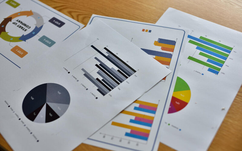 Startup company charts printed on desk with analysis notes