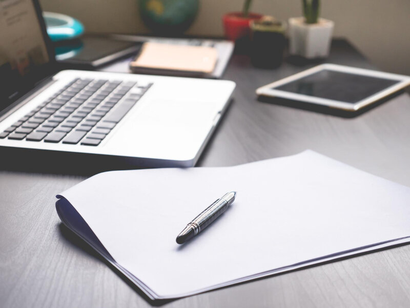 Workspace with pen paper laptop and tablet